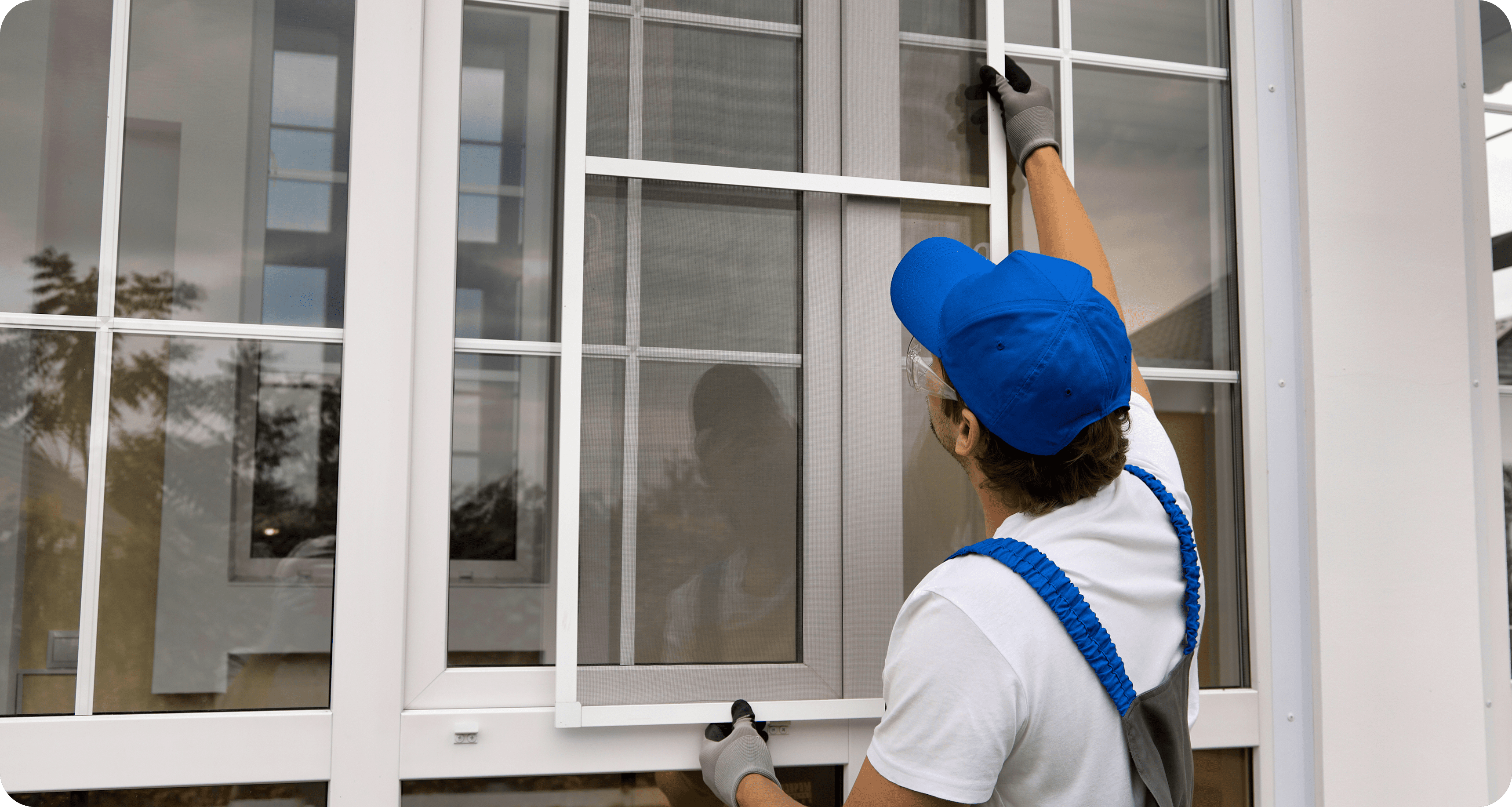Worker installing window screen